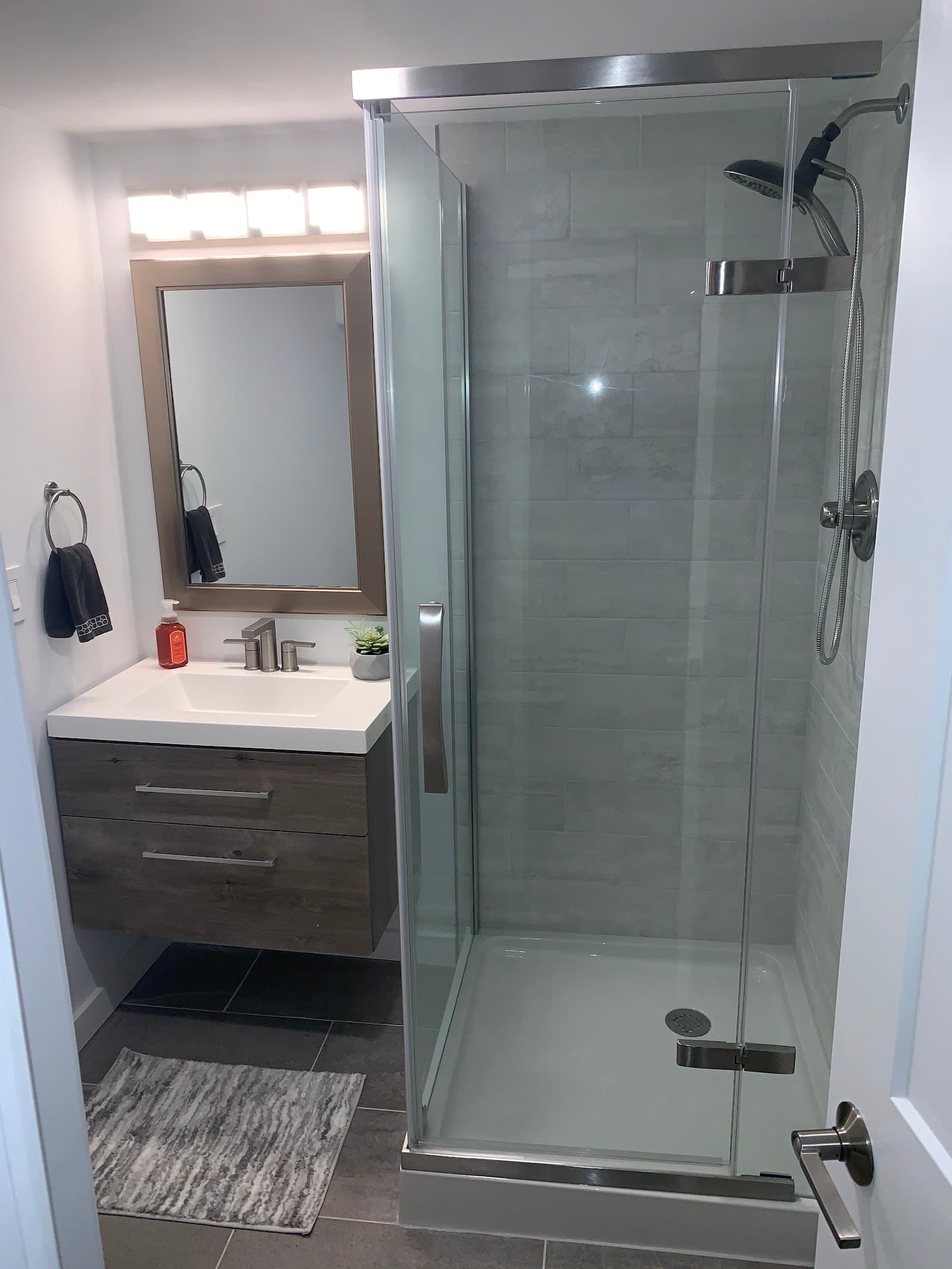 Glass shower enclosure with a floating vanity